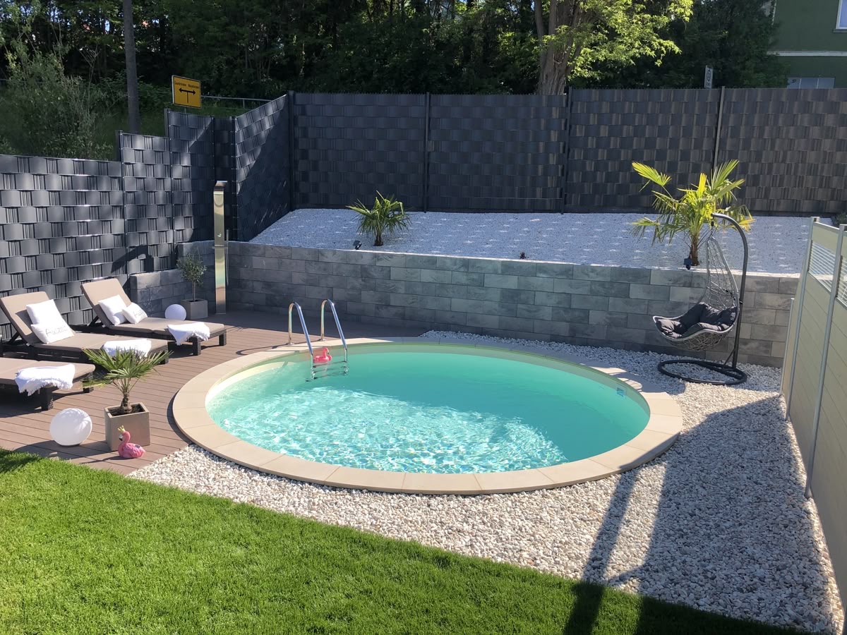 Runder Pool im Garten mit Sonnenliegen
